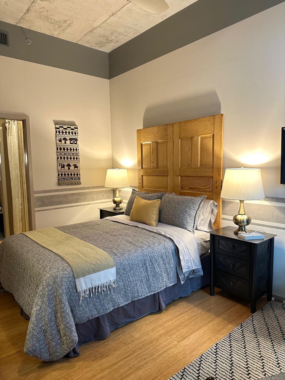 Nashville Gulch — After, guest bedroom with reclaimed wood door headboard, woven wall hanging and gold lamps