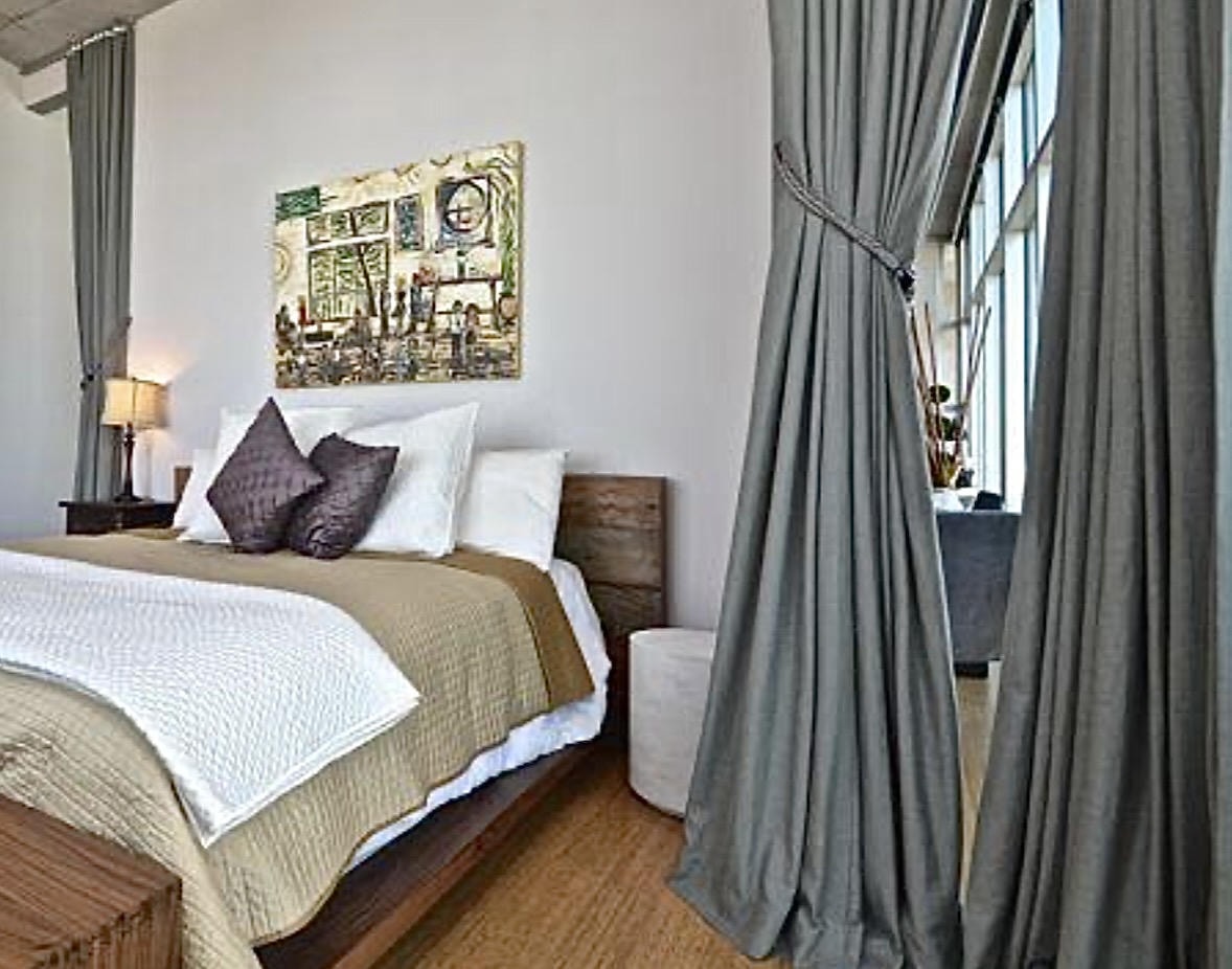 Nashville Gulch — Before, bedroom with wood platform bed and grey curtains