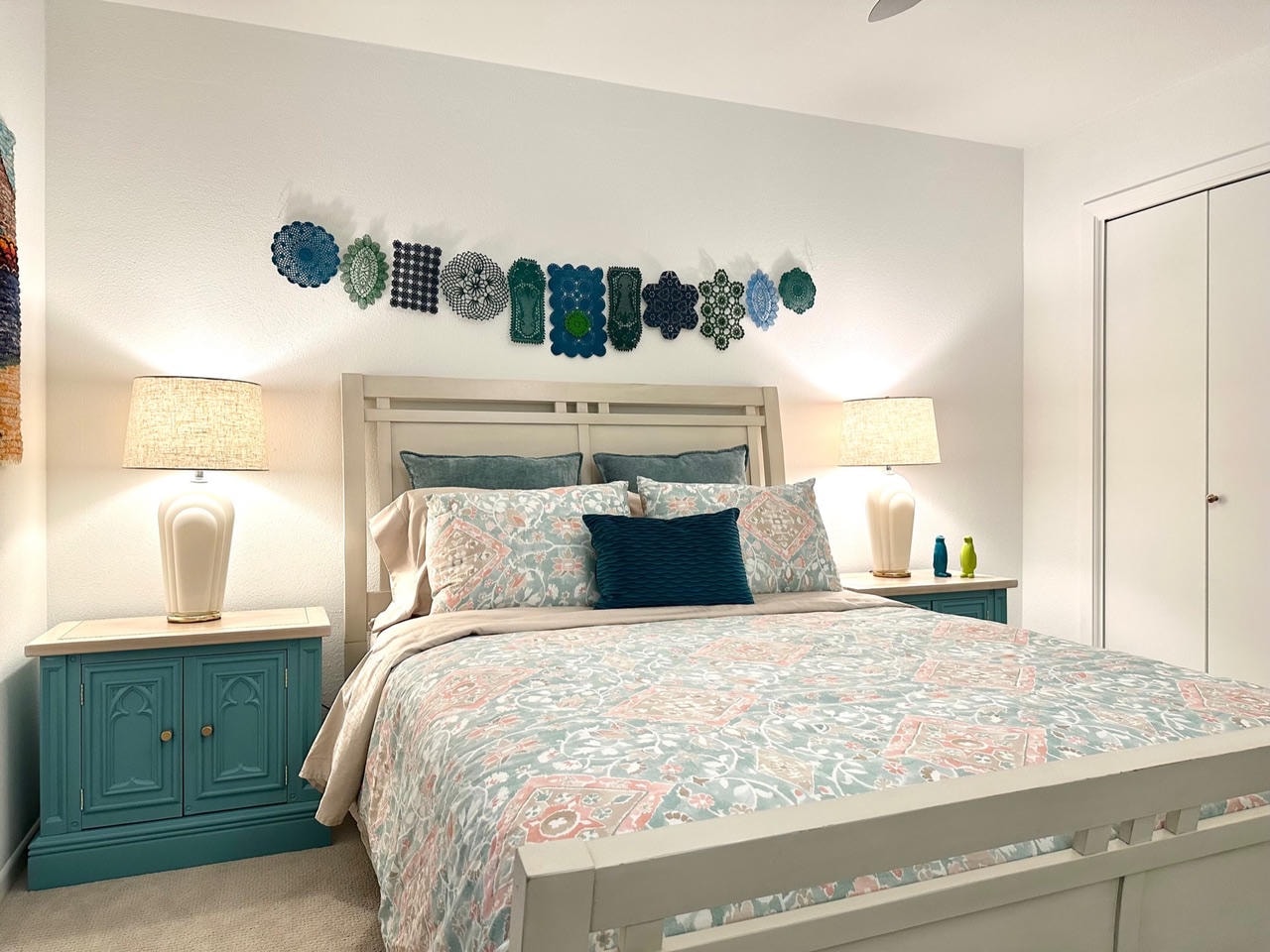 Austin Trail — After, master bedroom with teal nightstands, doily wall art garland and floral bedding