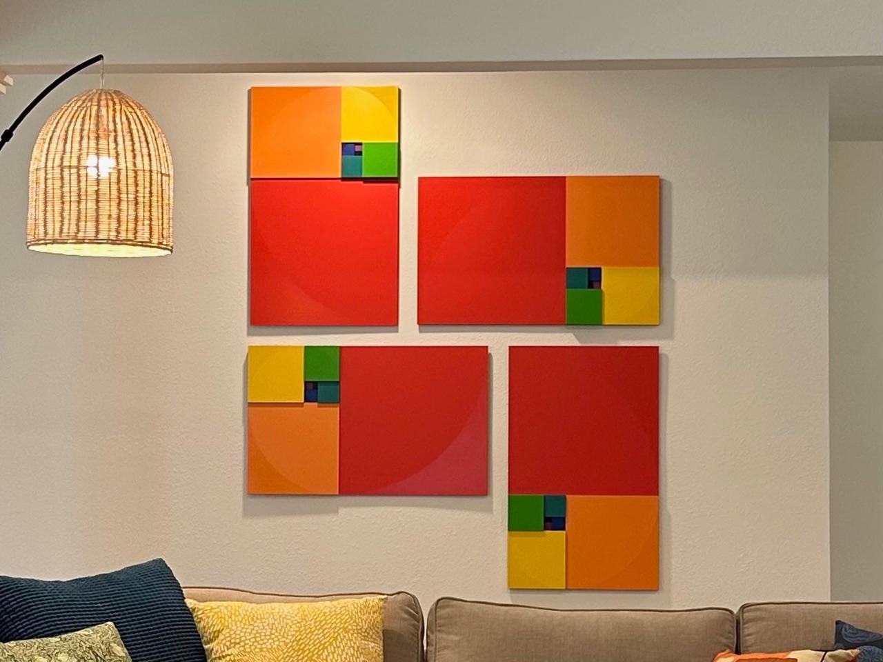 Four-panel color block canvas series in red, orange, yellow and green with Fibonacci spiral motif