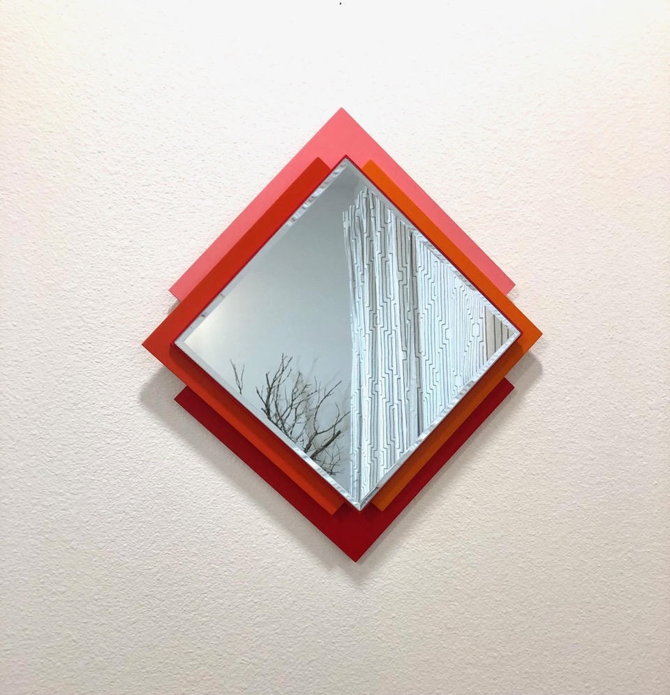 Diamond mirror with layered red and orange geometric frame
