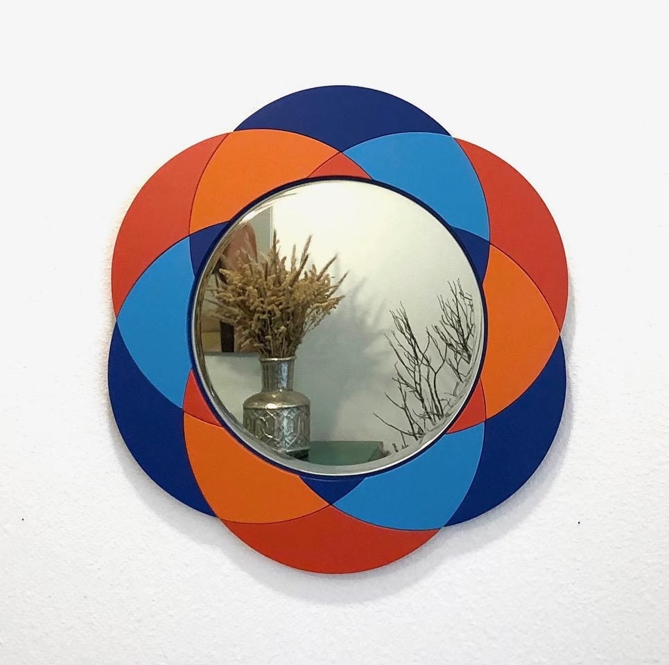 Round convex mirror with navy, orange and blue petal flower frame