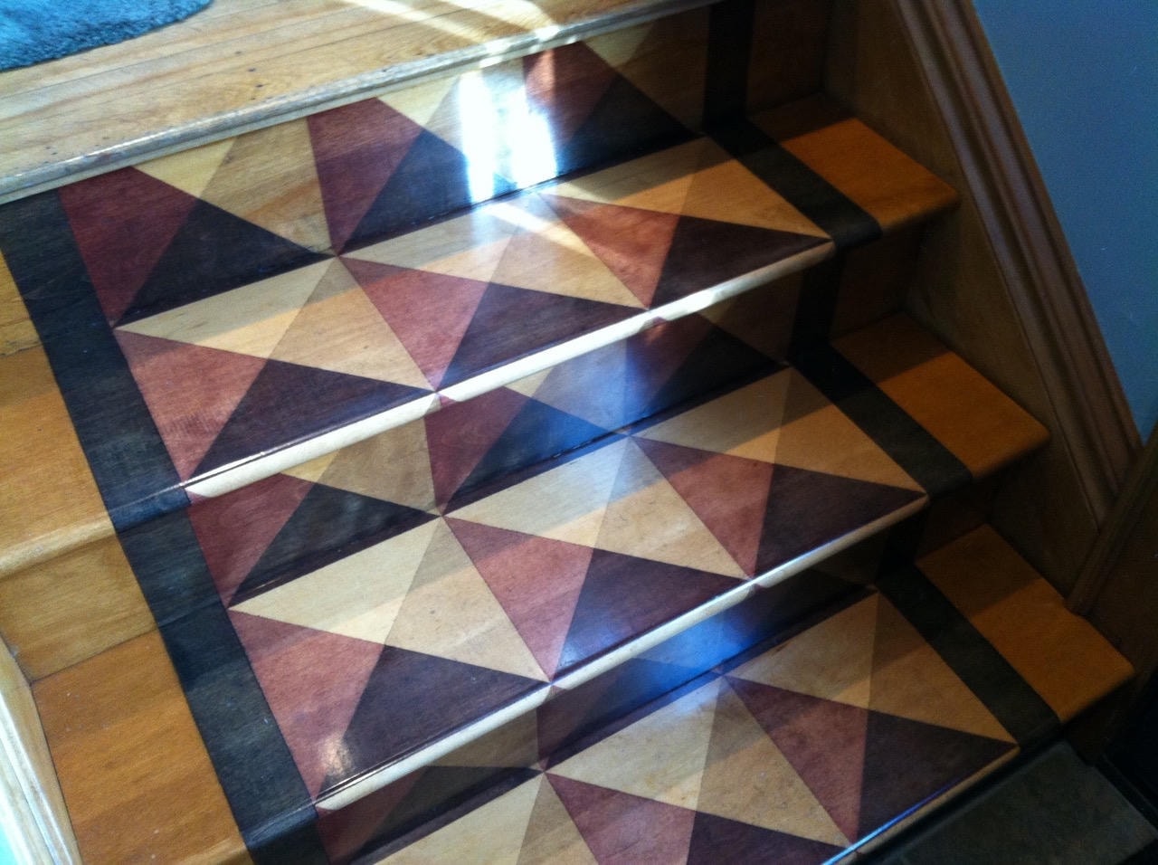 Geometric wood inlay stair runner with burgundy, black and natural wood tones