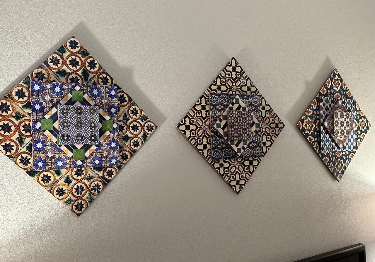 Three diamond-shaped decorative tile art pieces mounted on a wall