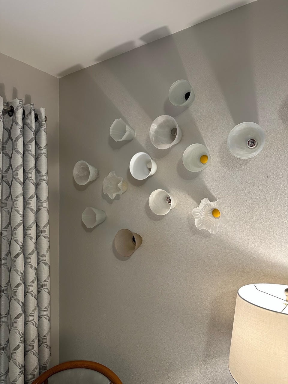 Wall-mounted sculptural ceramic cup and bowl objects in white and neutral tones