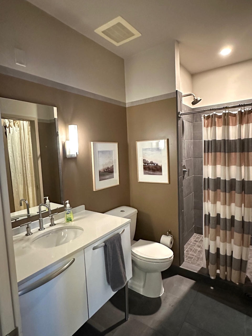 Nashville Gulch — After, bathroom with white vanity, grey tile and striped shower curtain