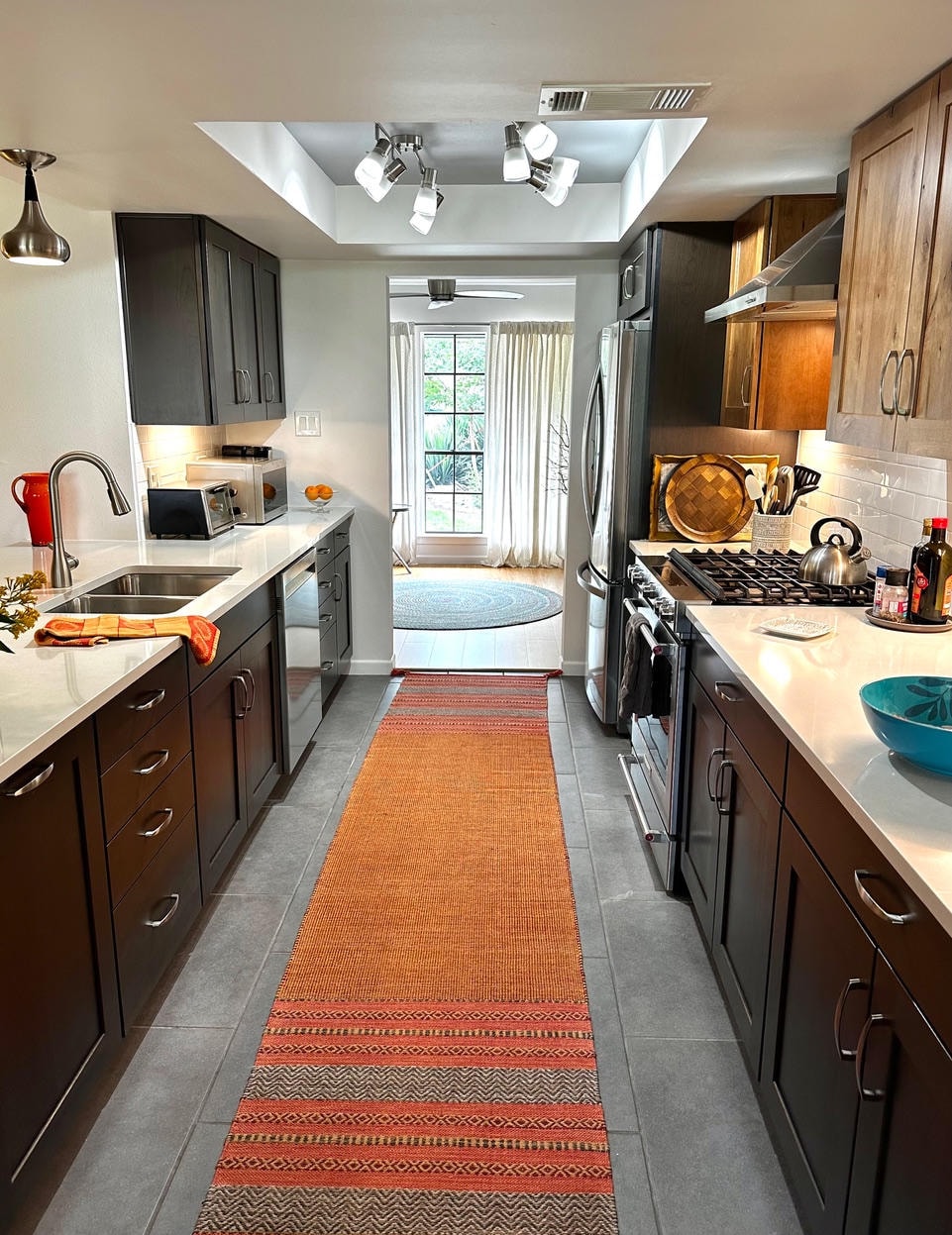 Austin Rock — After, galley kitchen with dark cabinets and orange runner rug