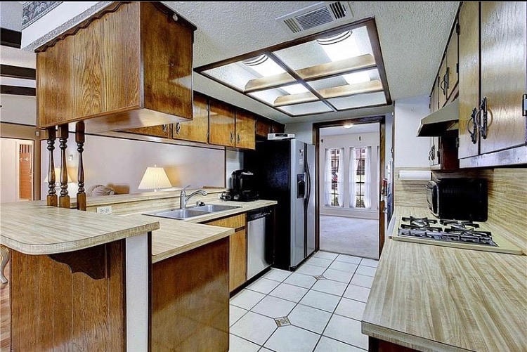 Austin Rock — Before, kitchen with wood cabinets and tile floor, angle 1