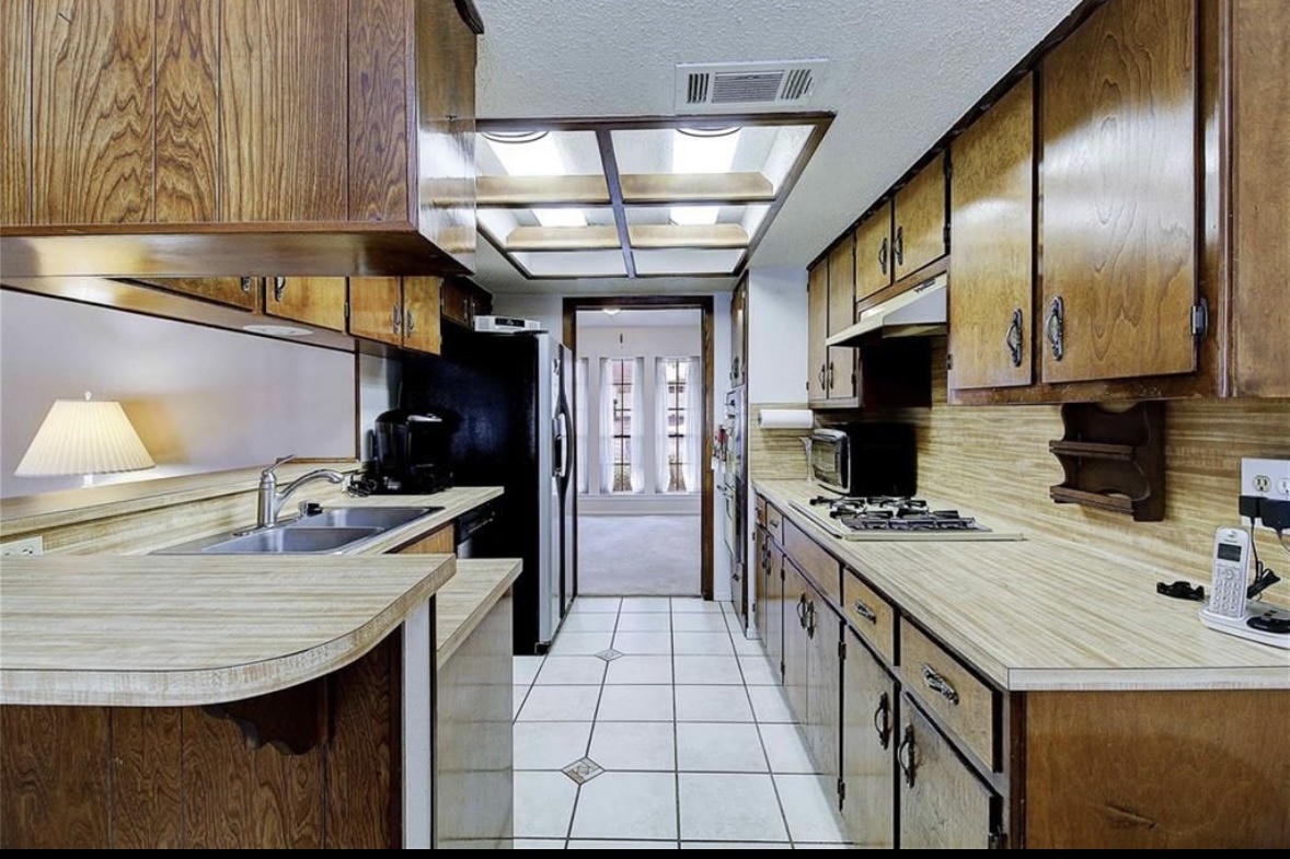 Austin Rock — Before, kitchen with wood cabinets and tile floor, angle 2