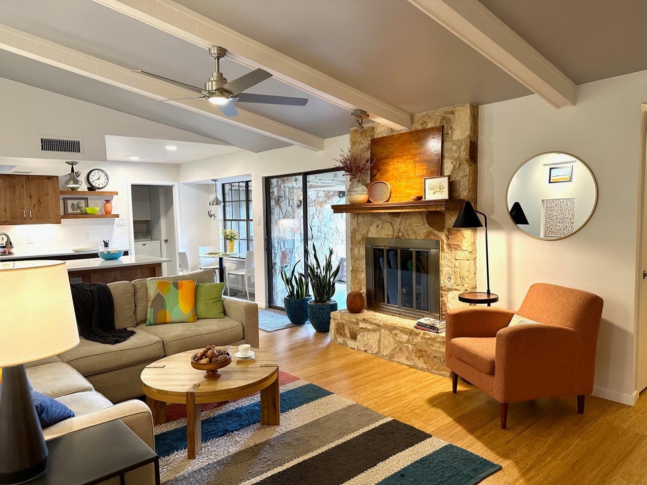 Austin Rock — After, living room with stone fireplace, sectional and orange chair