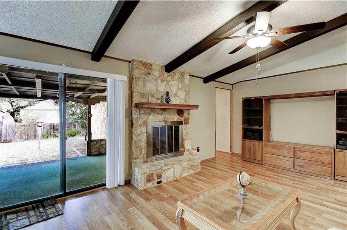 Austin Rock — Before, living room with stone fireplace and built-ins